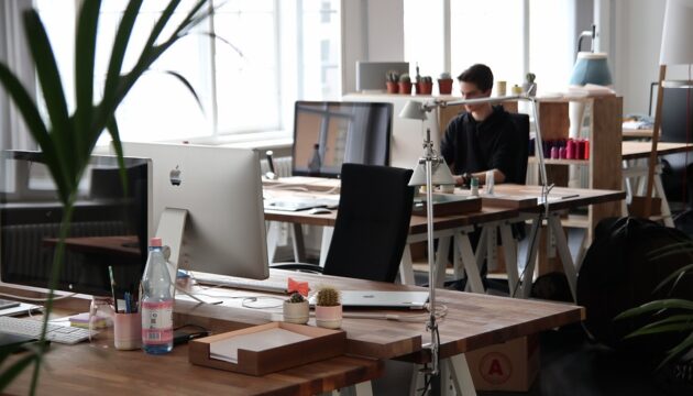 Модерно coworking пространство с работни места и служител на лаптоп
